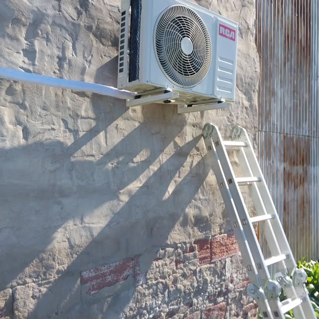 Unidad exterior de aire acondicionado instalada sobre fachada
